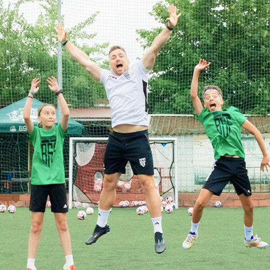 Děti skáčou s trenérem před kamerou